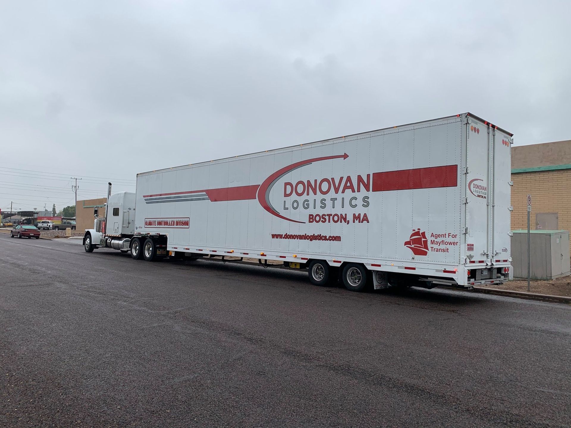White Donovan Logistics trailer parked on a wet road under an overcast sky