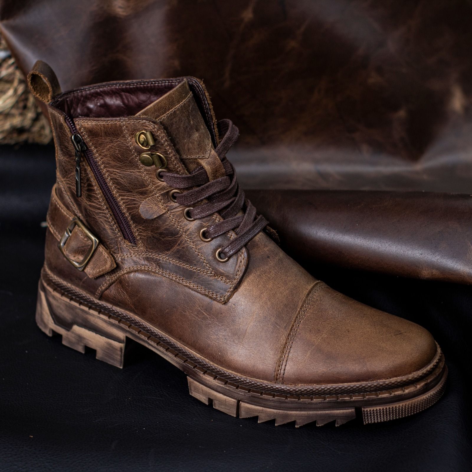 Un par de botas de cuero color canela con cordones, cremalleras laterales y suela gruesa