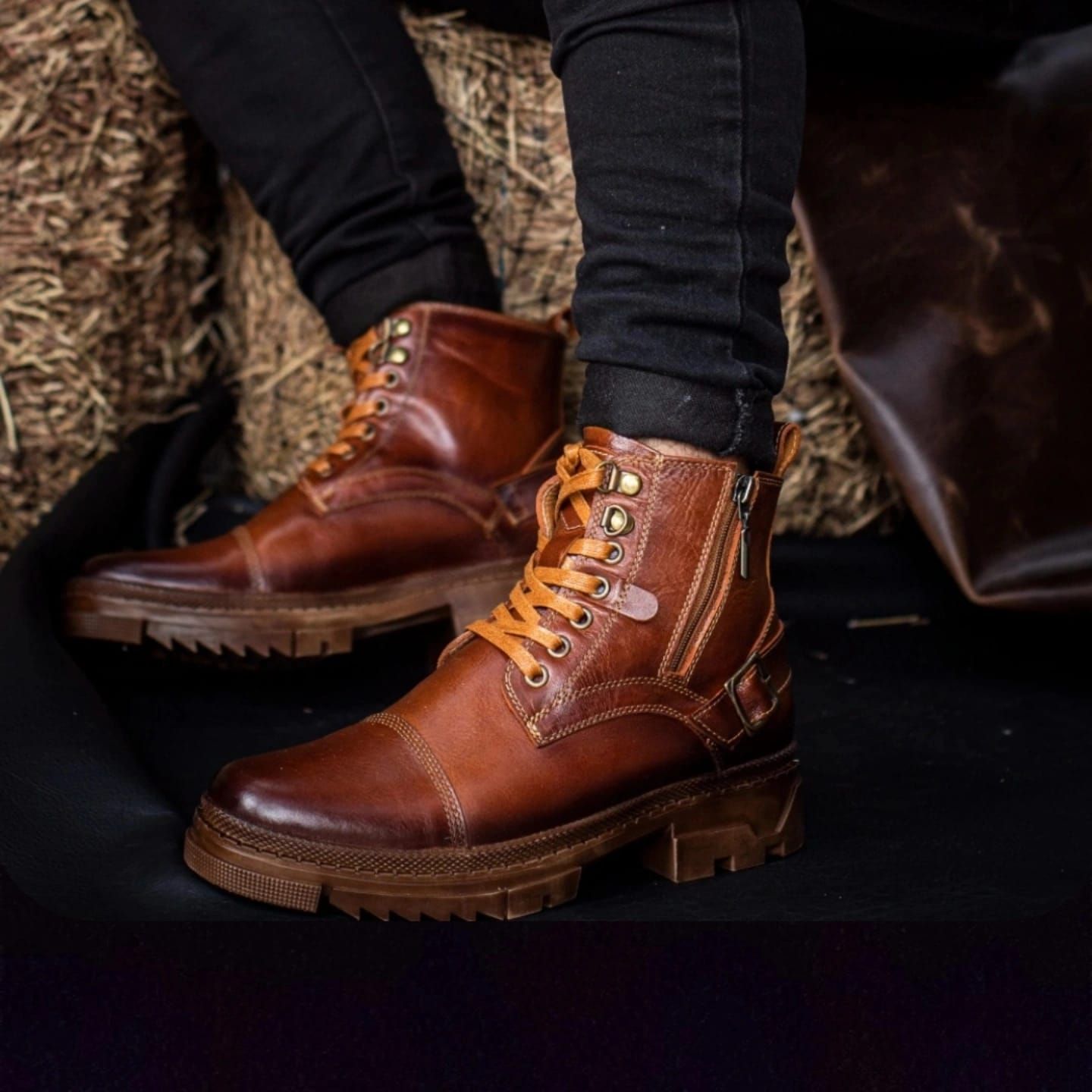 Un par de botas de cuero color canela con cordones, cremalleras laterales y suela gruesa