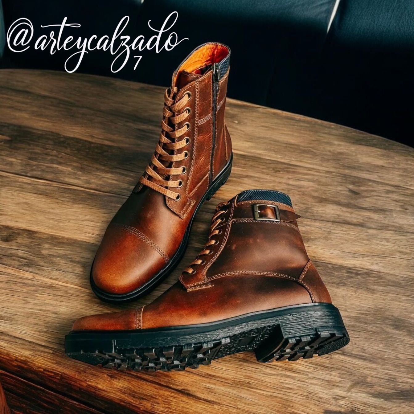 Un par de botas marrones de cuero con cordones, hebilla lateral y suela oscura con relieve