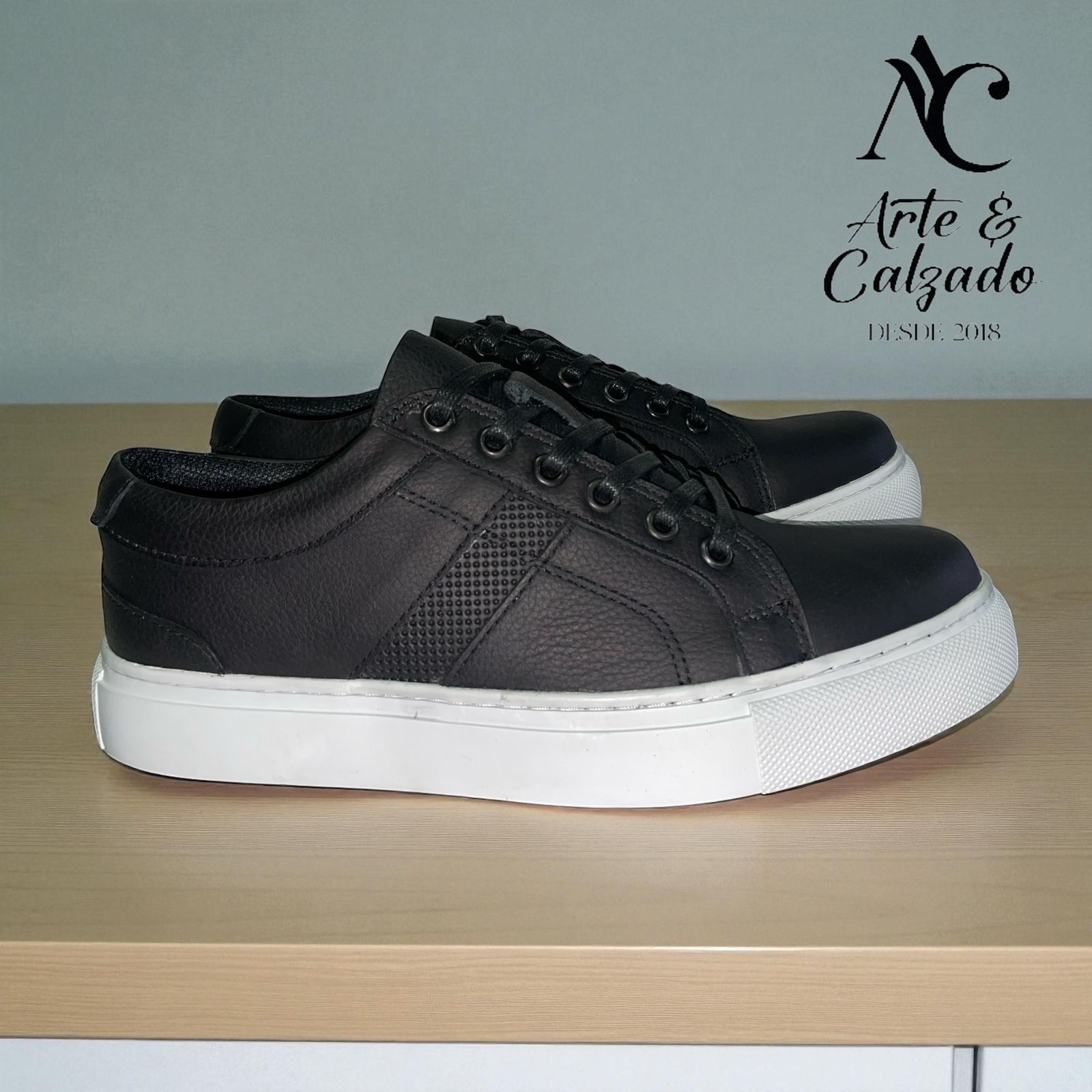 Zapatillas deportivas informales de cuero marrón puestas sobre un suelo de hormigón gris