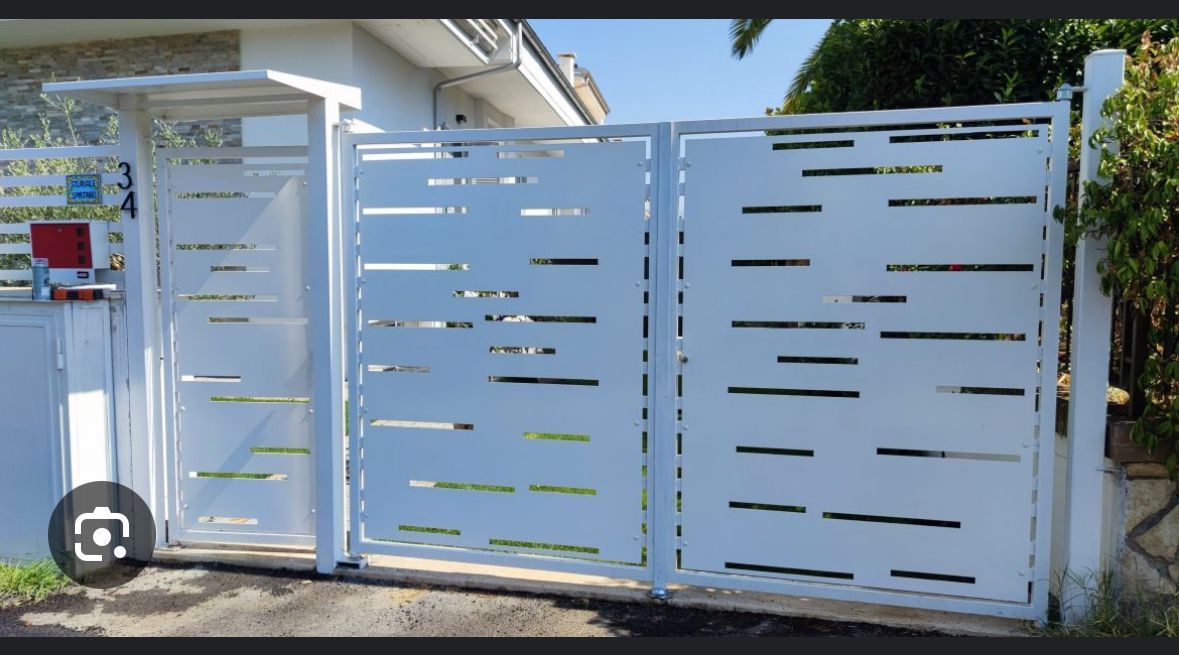 Cancello e recinzione moderni a doghe bianche all'ingresso di una casa, esposti alla luce del sole.