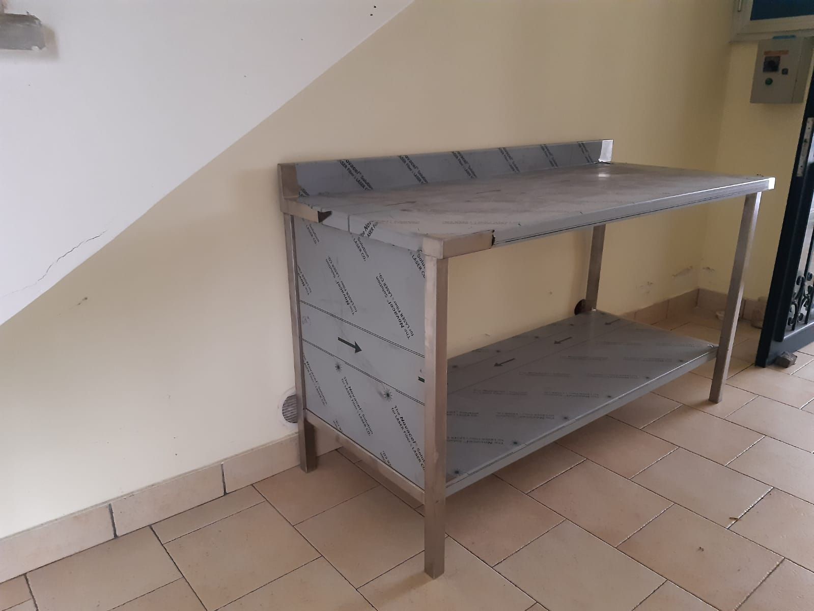 Scaffale metallico sottoscala in una stanza piastrellata