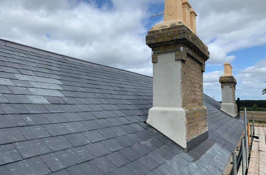 Two chimneys are on the roof of a building.