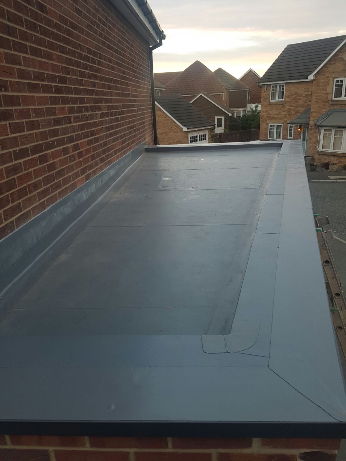 A roof with a rubber roof on top of a brick building.
