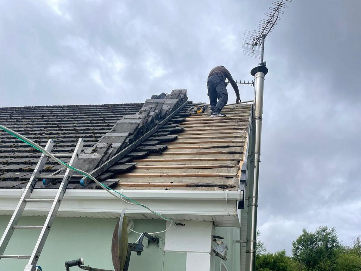 A man is working on the roof of a house.