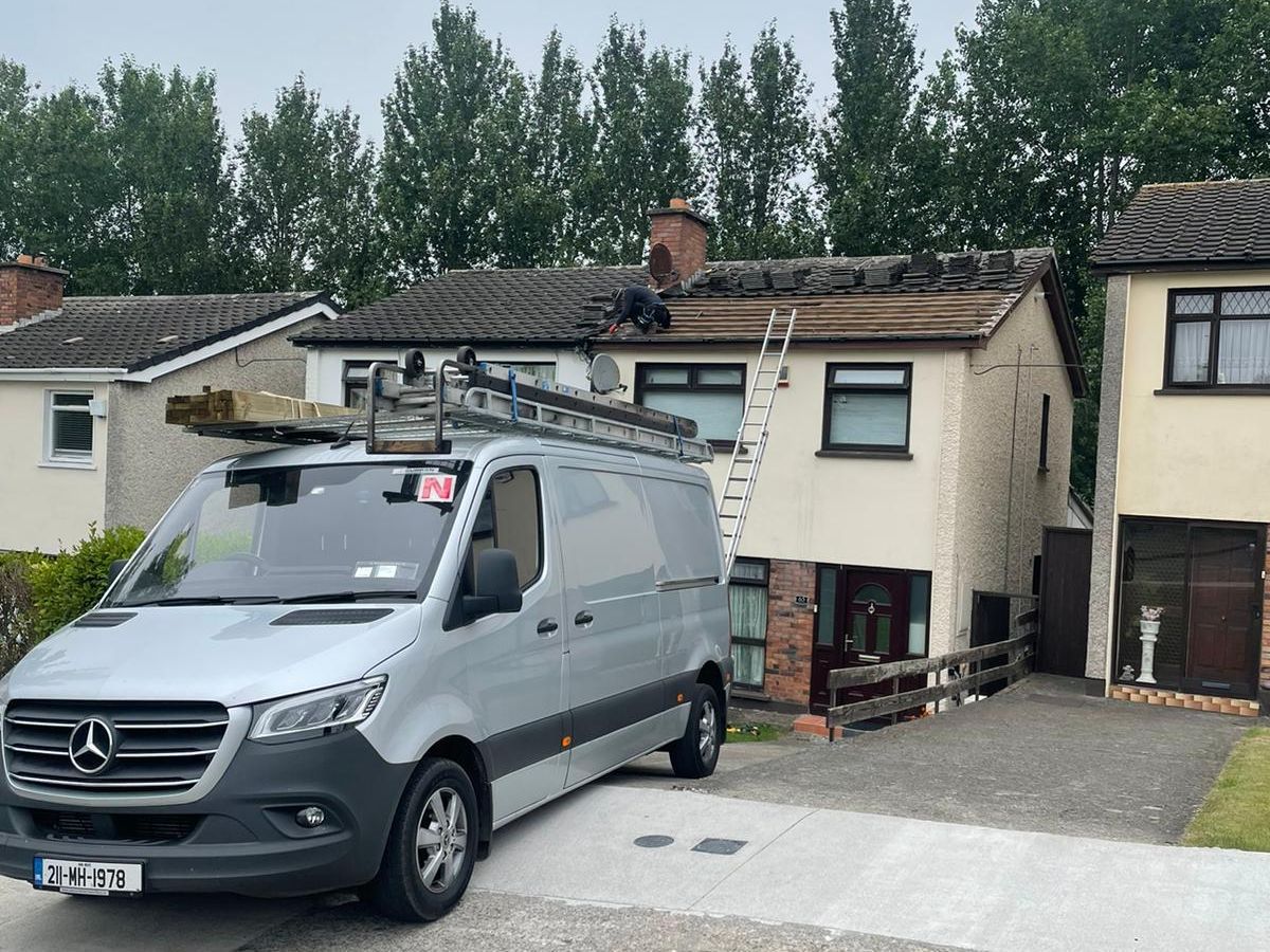 A mercedes van is parked in front of a house.