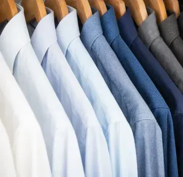 Five men's neckties with various patterns and colors—light grey, blue, pale green, and dark navy—laid side-by-side.