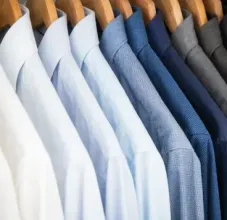 Five men's neckties with various patterns and colors—light grey, blue, pale green, and dark navy—laid side-by-side.