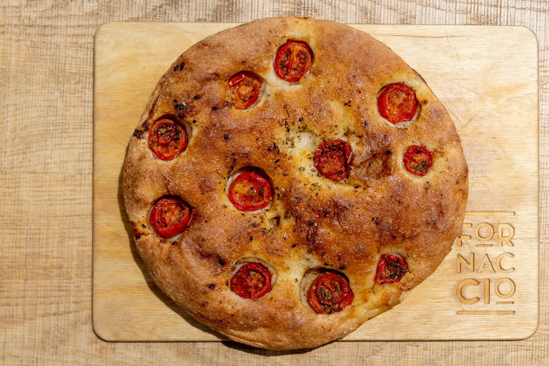 Primo piano di un pane piatto dorato con fossette, impilato uno sull'altro.