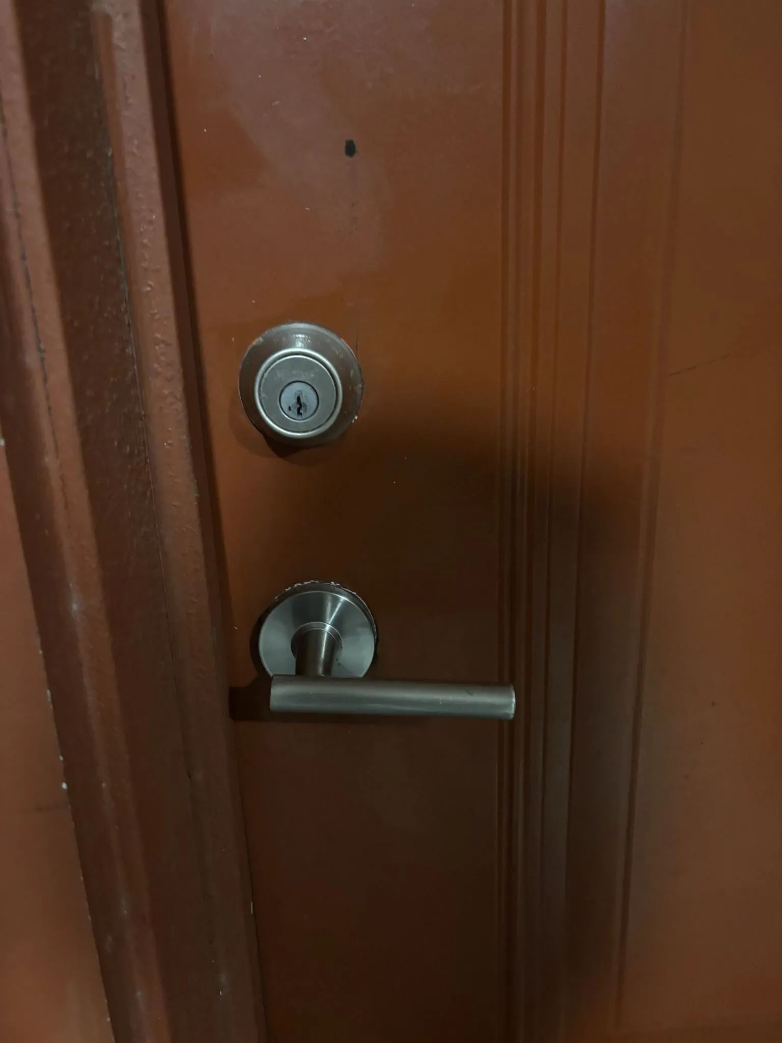 Brown door with silver doorknob and deadbolt.