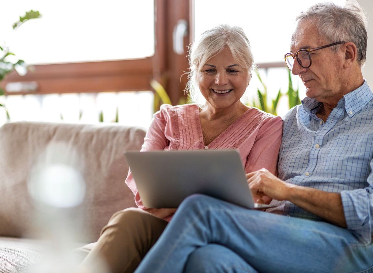 Mature couple smiles warmly during a video call.