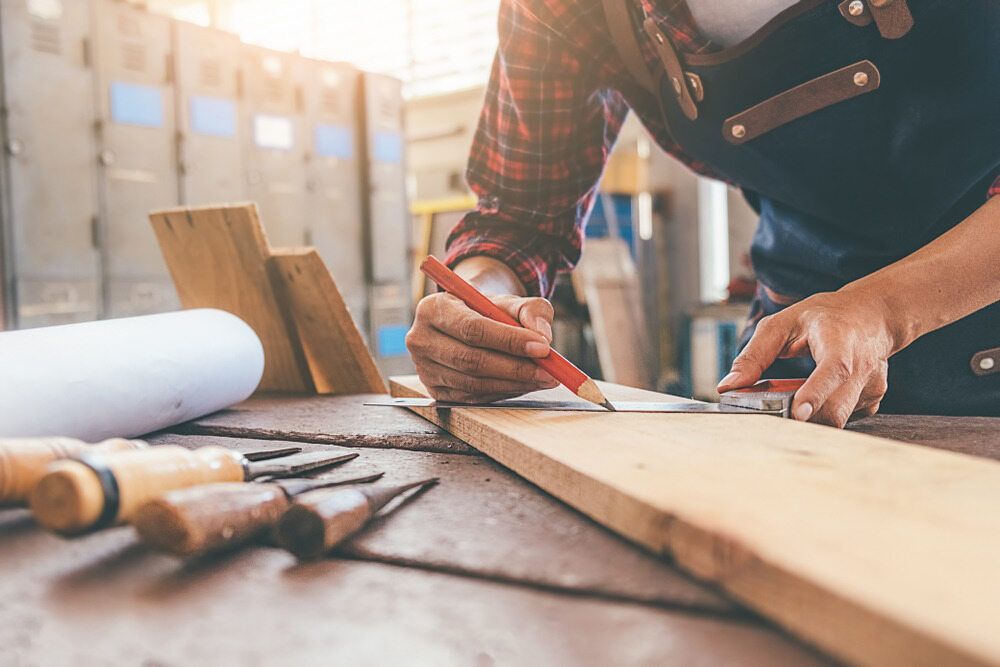 A Person in a Workshop, Wearing a Plaid Shirt and Apron — Northco Constructions In Muirhead, NT