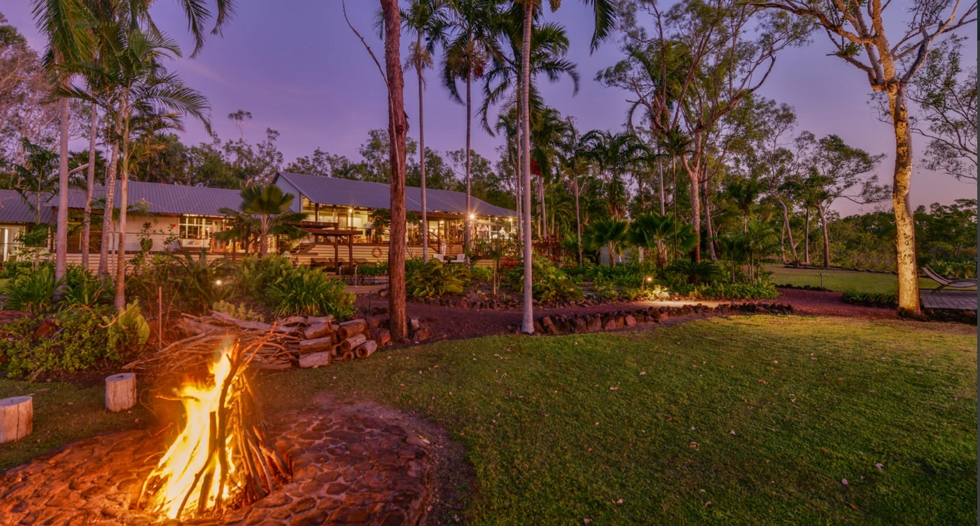 Evening View of a Bonfire on a Grassy Lawn With a Building — Northco Constructions In Muirhead, NT