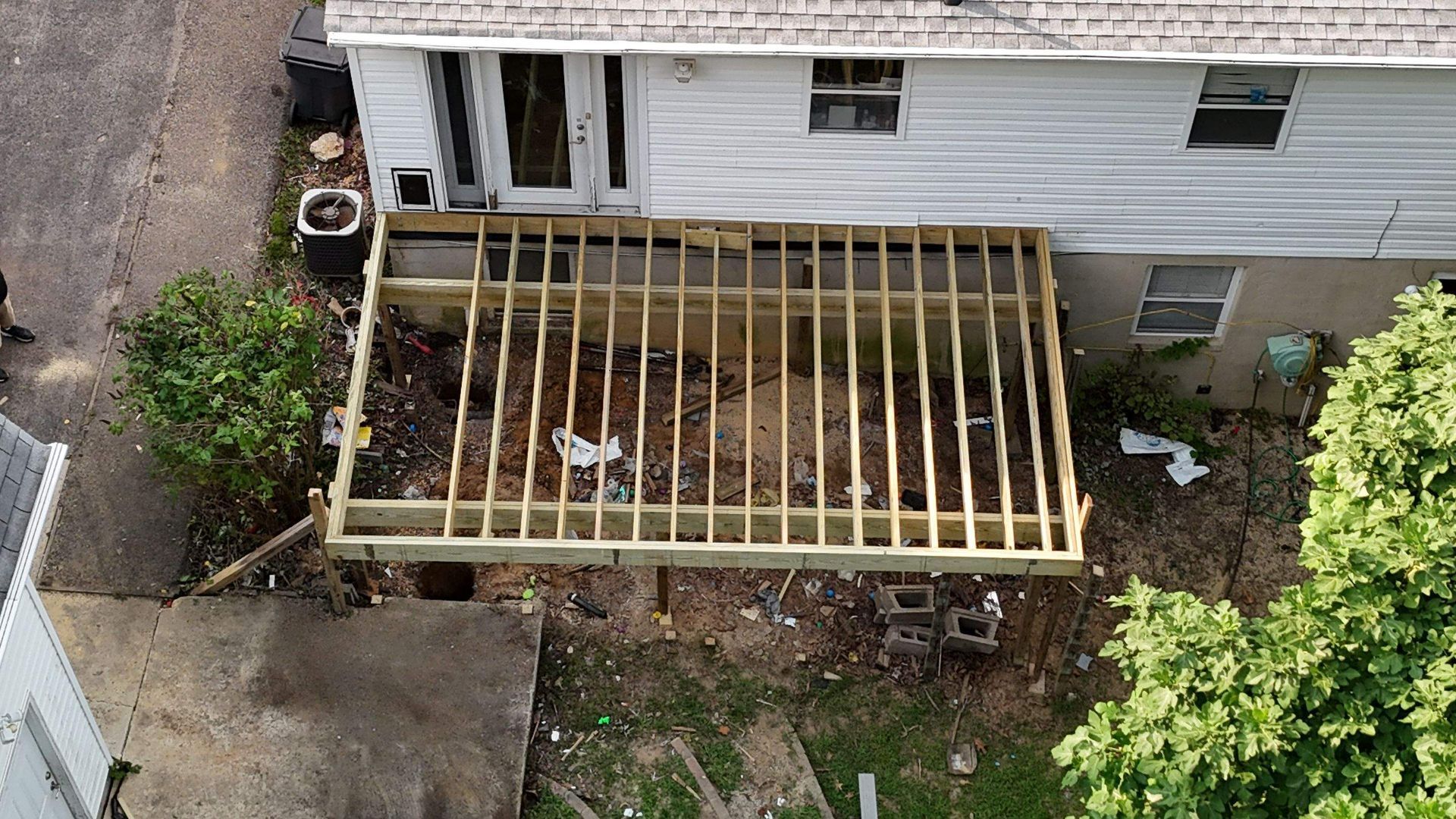 An aerial view of a house with a wooden deck under construction.
