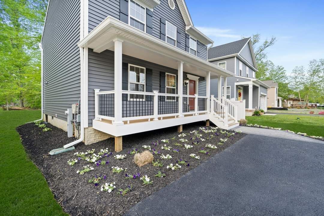 A gray house with a white porch and stairs