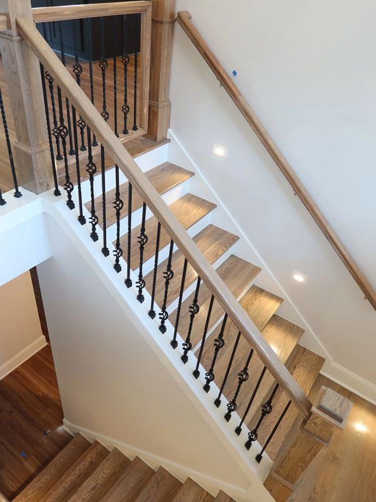 A staircase with wooden steps and a wrought iron railing