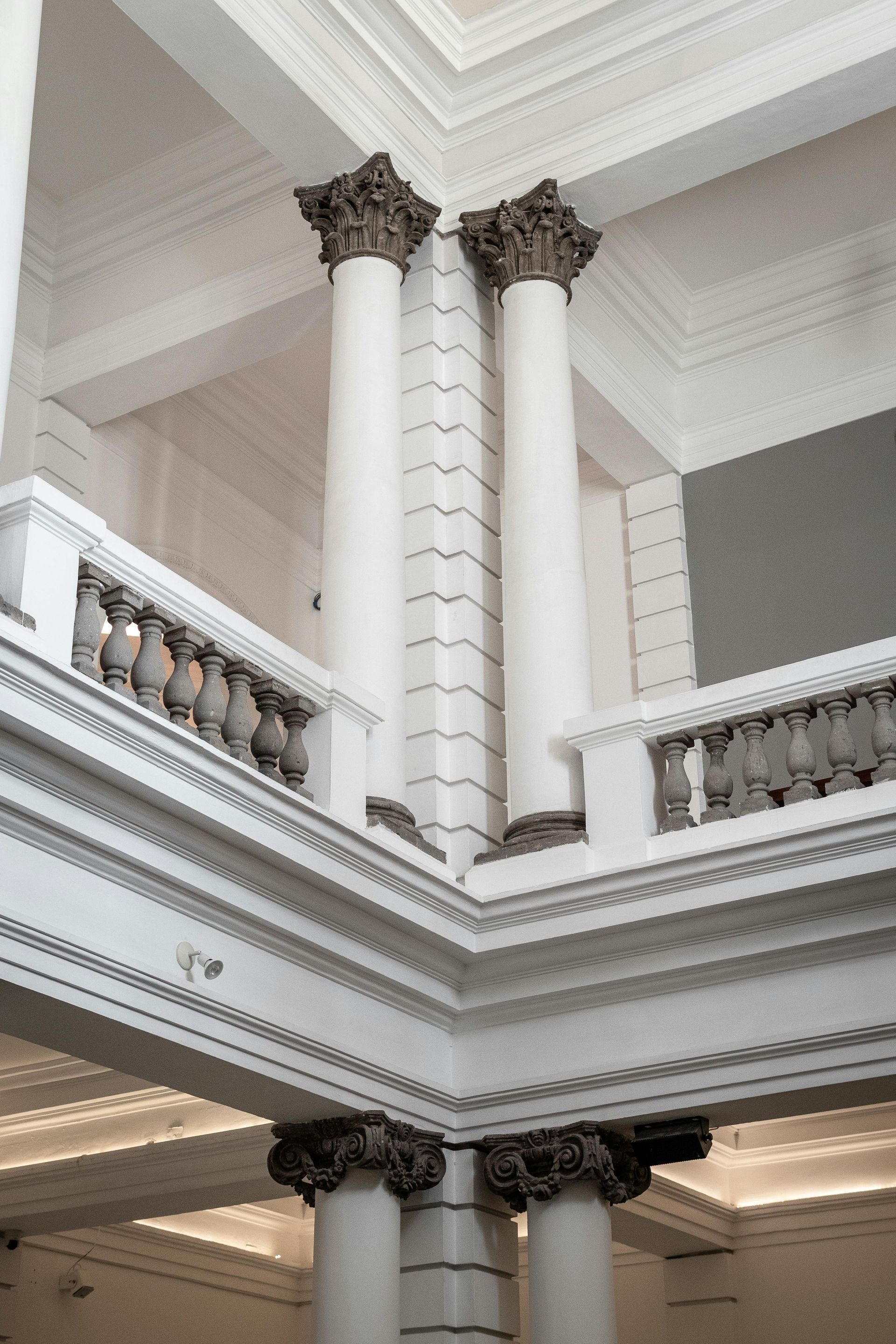 Looking up to the second floor in a house with high ceilings and crown molding.