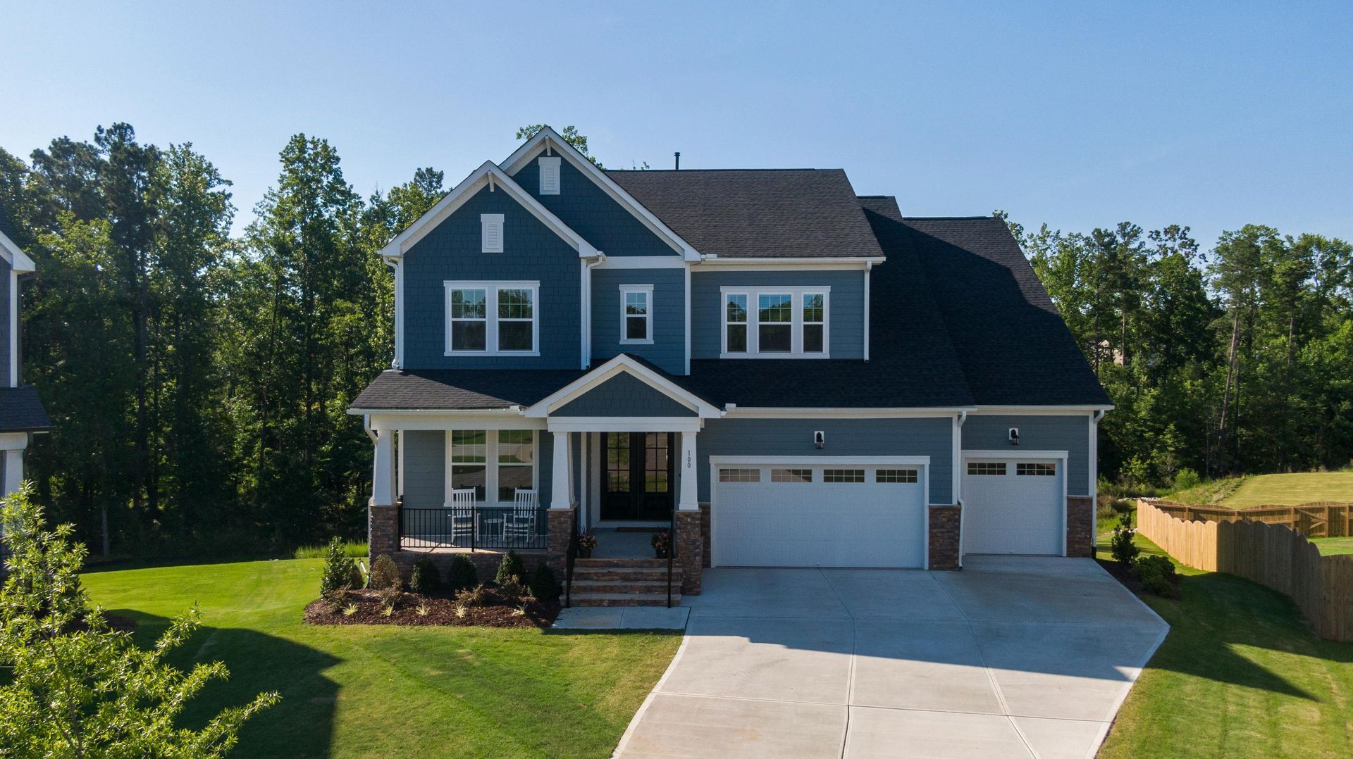 Blue two story house with a three car garage in a subdivision of a Boise, Idaho suburb.