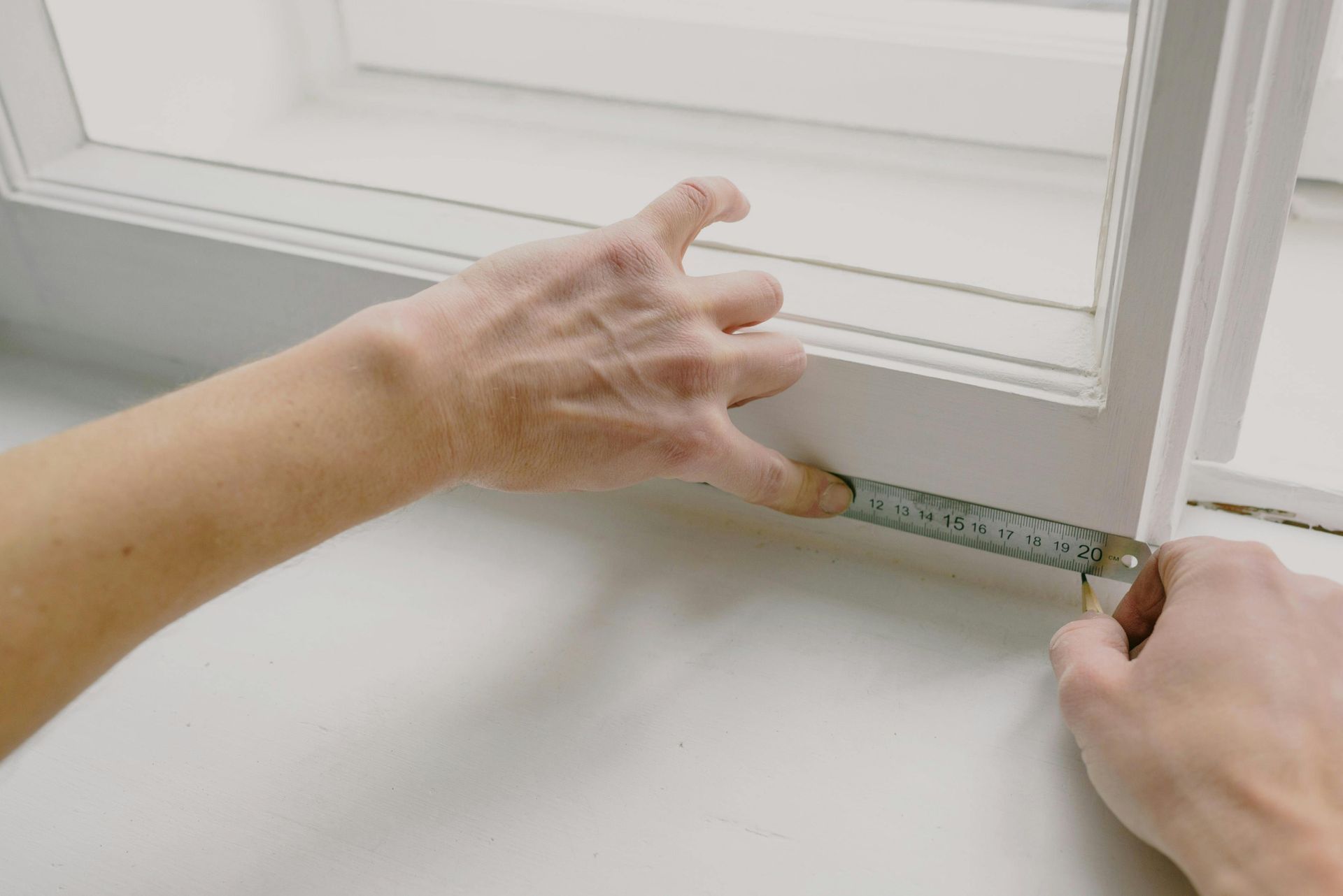 Trim carpenter measuring a window for installation.