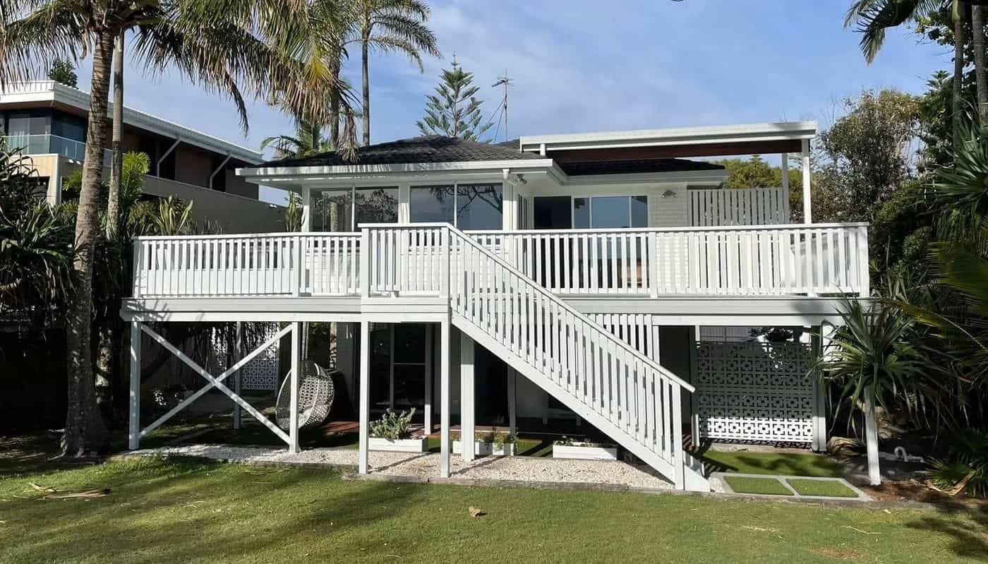 A White House With A Large Deck And Stairs Surrounded By Palm Trees — Tweed Heads Painting Service In Condong, NSW