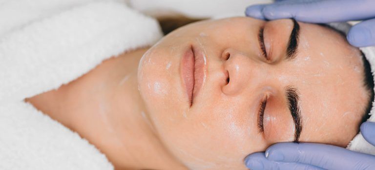 Une femme reçoit un soin du visage dans un spa.