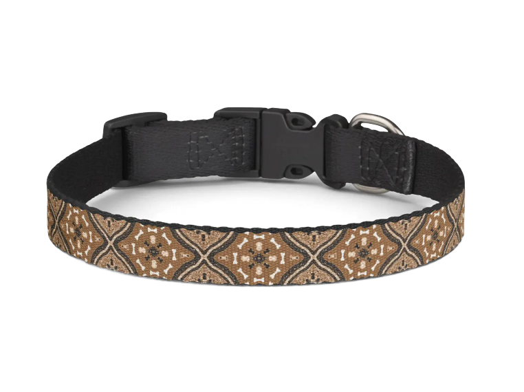 Black dog collar with tan patterned fabric band on a white background