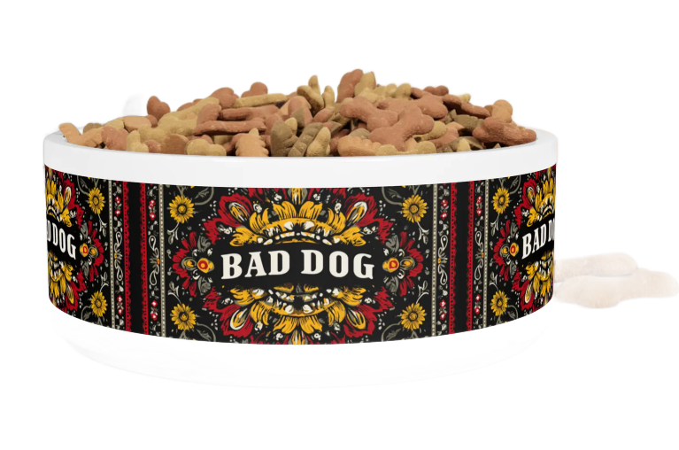 Dog food bowl labeled “BAD DOG” with a black floral pattern, filled with kibble.