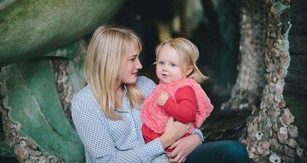A woman is holding a little girl in her arms.