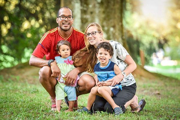 A family is posing for a picture in a park.