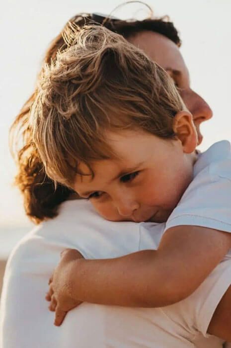 A woman is holding a little boy in her arms.