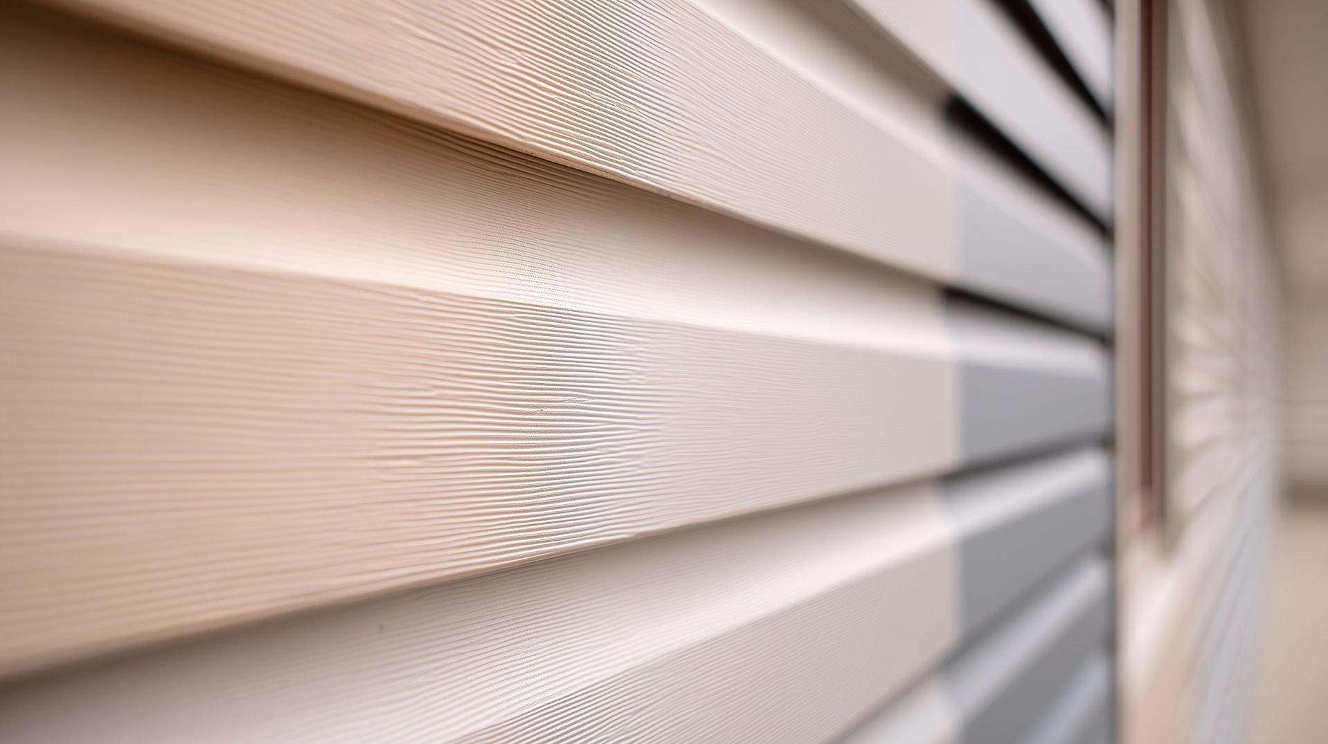 Close-up of off-white vinyl panels during a professional siding replacement project for a home. Close-up of off-white vinyl panels during a professional siding replacement project for a home.