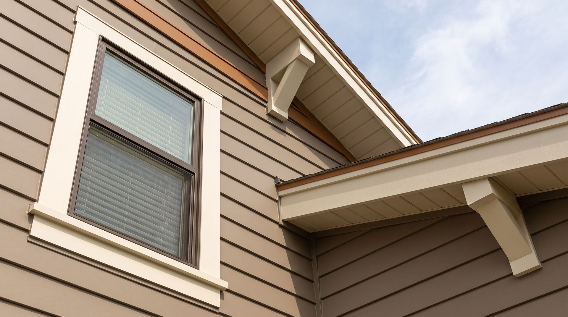Residential home exterior with newly installed engineered wood lap siding and updated gutters
