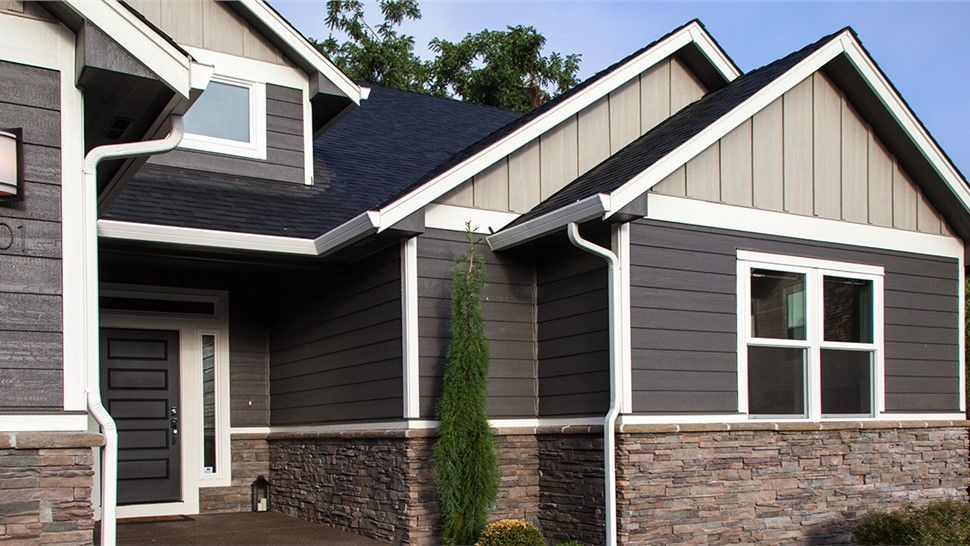 A house with a gray siding and a black roof | Siefken Roofing and Remodeling Services in Omaha, NE