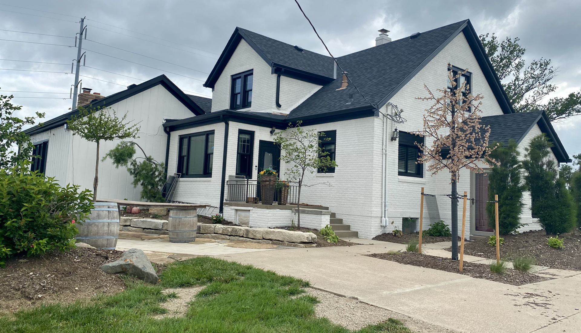 A large white house with a black roof is sitting on top of a lush green hillside | Roofing Projects | Siefken Roofing and Remodeling Services in Omaha, NE