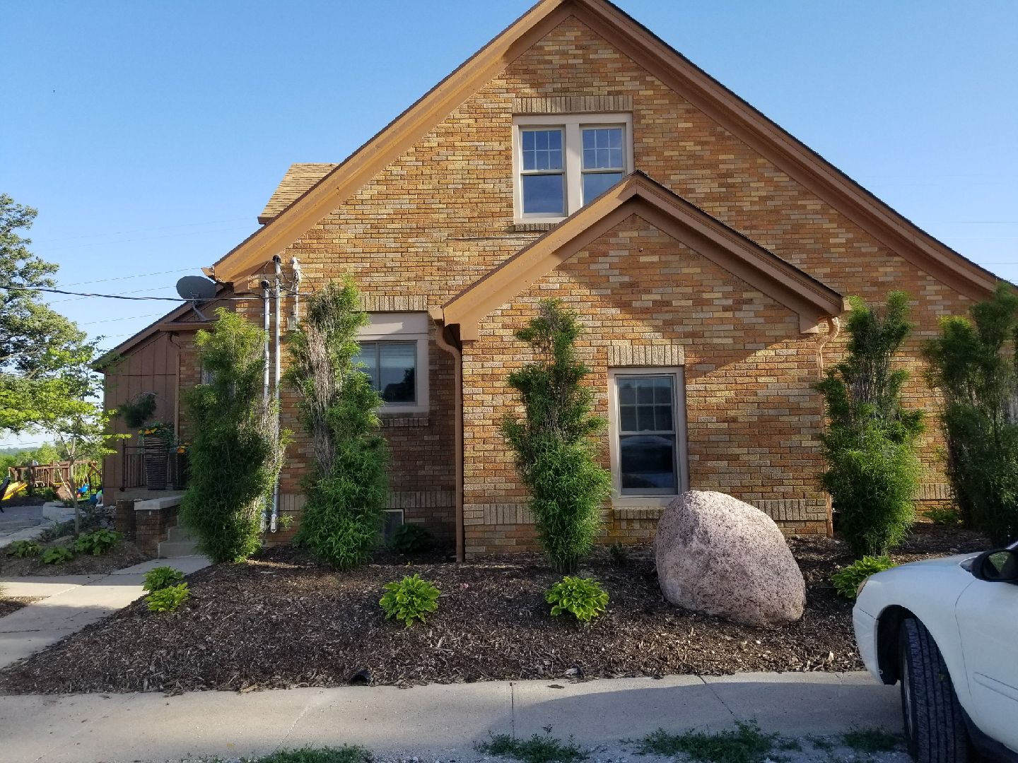 A brick house with a car parked in front of it  | Roofing Projects | Siefken Roofing and Remodeling Services in Omaha, NE