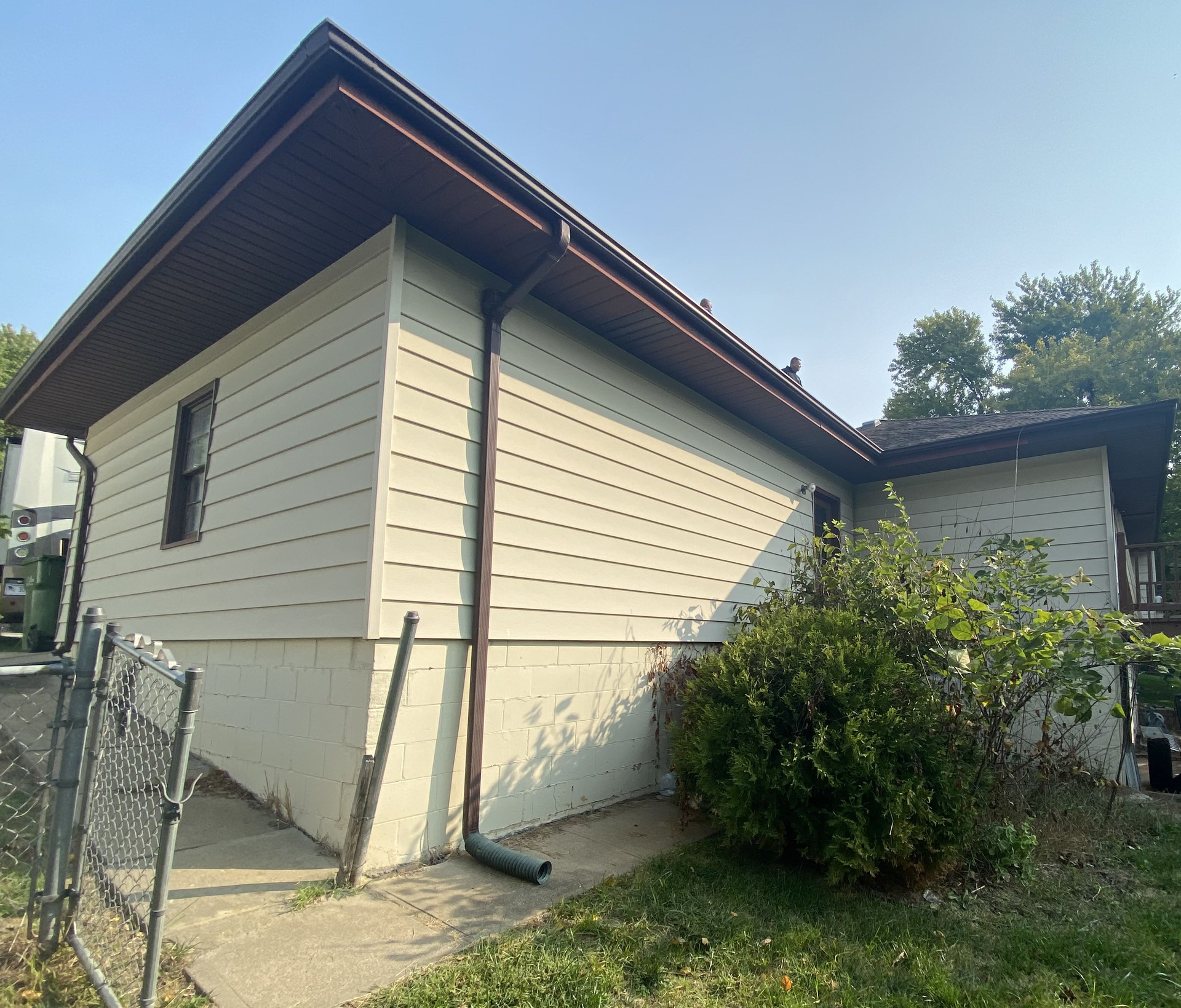 A white house with a brown roof and gutters | Siding Projects | Siefken Roofing and Remodeling Services in Omaha, NE