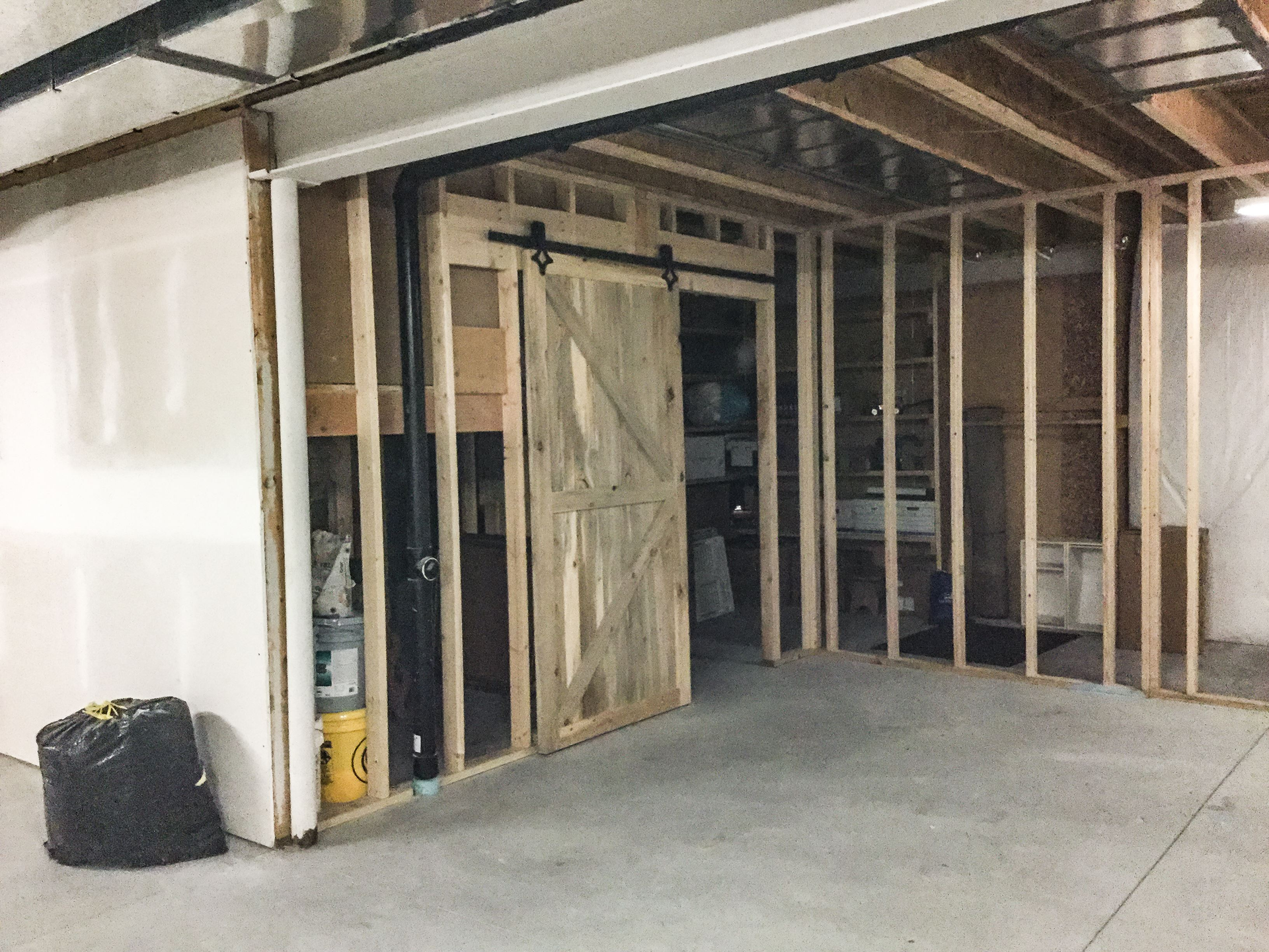 A basement under construction with a sliding barn door | Kitchen Projects | Siefken Roofing and Remodeling Services in Omaha, NE
