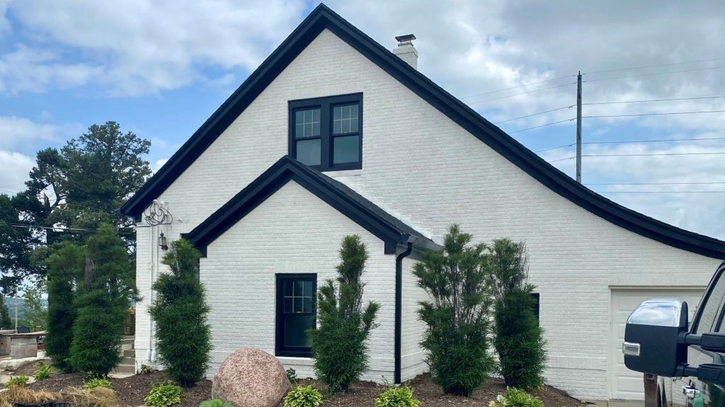 A white house with black trim and a black roof | Siefken Roofing and Remodeling Services in Omaha, NE