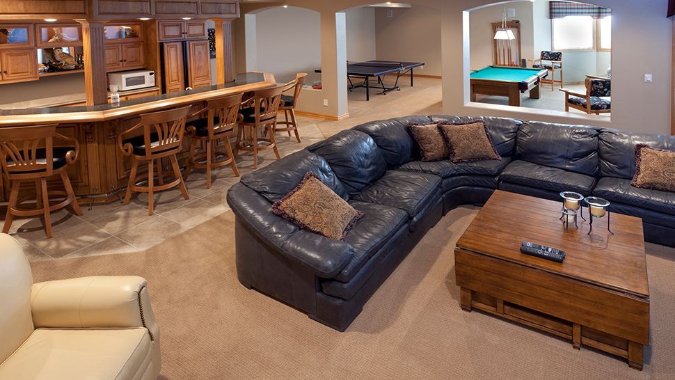 A living room with a large sectional couch and a pool table | Siefken Roofing and Remodeling Services in Omaha, NE