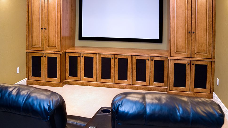 A home theater with two leather couches and a large screen | Siefken Roofing and Remodeling Services in Omaha, NE
