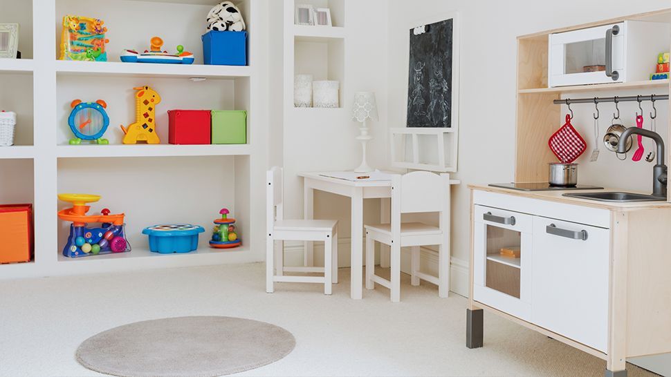 A child 's room with a table , chairs , shelves , and a toy kitchen | Siefken Roofing and Remodeling Services in Omaha, NE