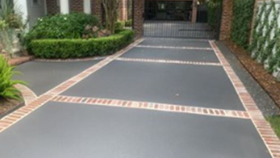 A driveway with a brick border is leading to a house | Kitchen Projects | Siefken Roofing and Remodeling Services in Omaha, NE
