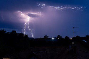 Lightning strikes in the night sky over a city | Kitchen Projects | Siefken Roofing and Remodeling Services in Omaha, NE
