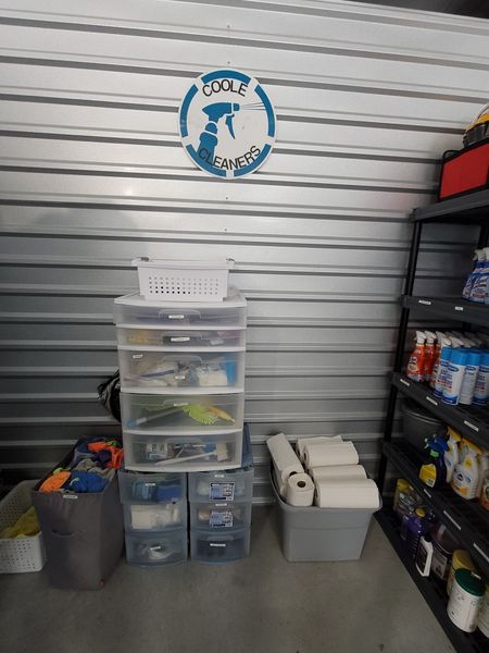 Storage unit interior with plastic bins, shelving, and a circular logo.