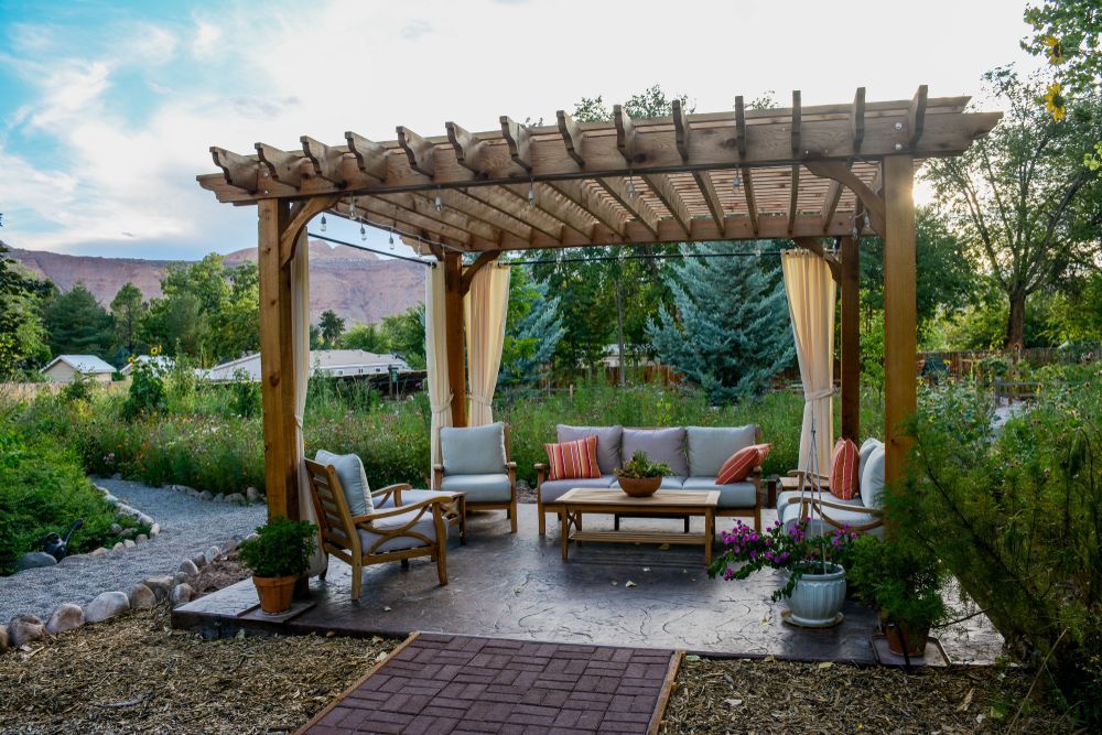 A Wooden Pergola Covers an Outdoor Seating Area — Coastbuilt Building Services in Thrumster, NSW