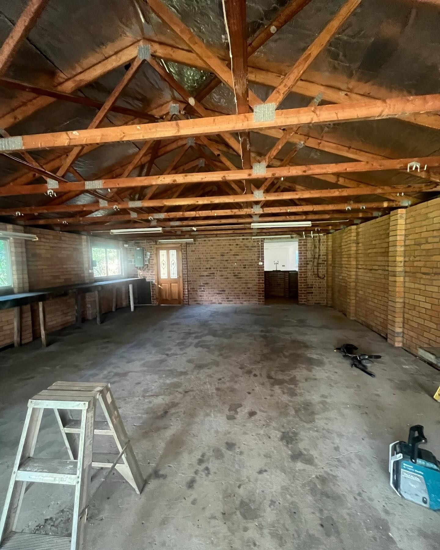 An Empty, Rustic Room With Exposed Wooden Rafters — Coastbuilt Building Services in Thrumster, NSW