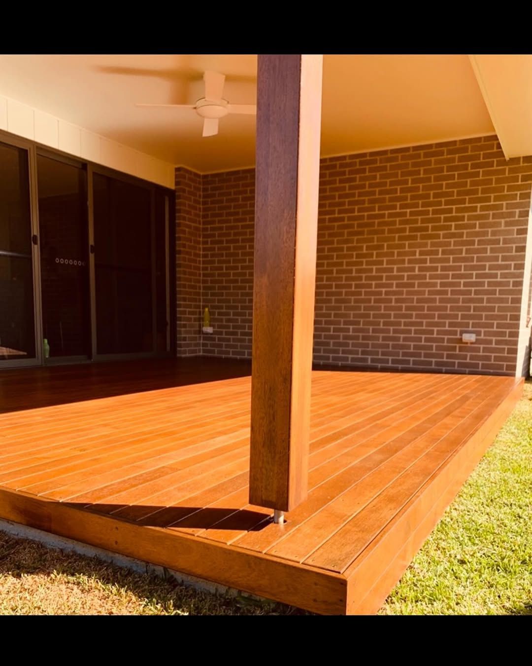 A Polished Wooden Deck With a Central Support Post — Coastbuilt Building Services in Thrumster, NSW