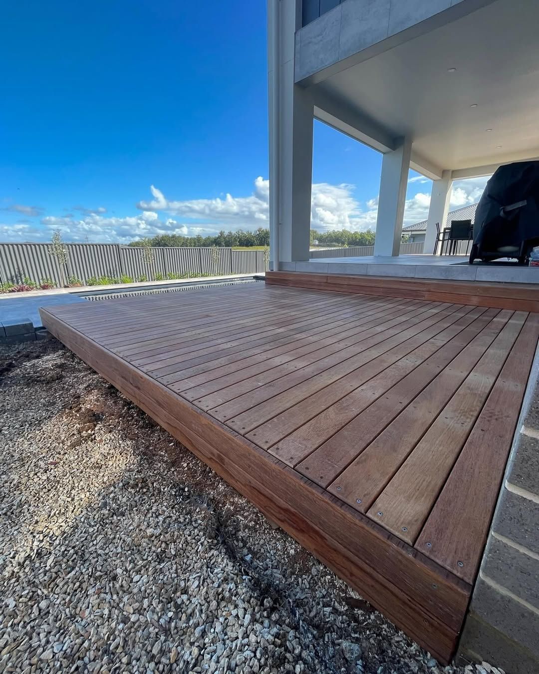 A Newly Built Wooden Deck Extends From a House — Coastbuilt Building Services in Thrumster, NSW