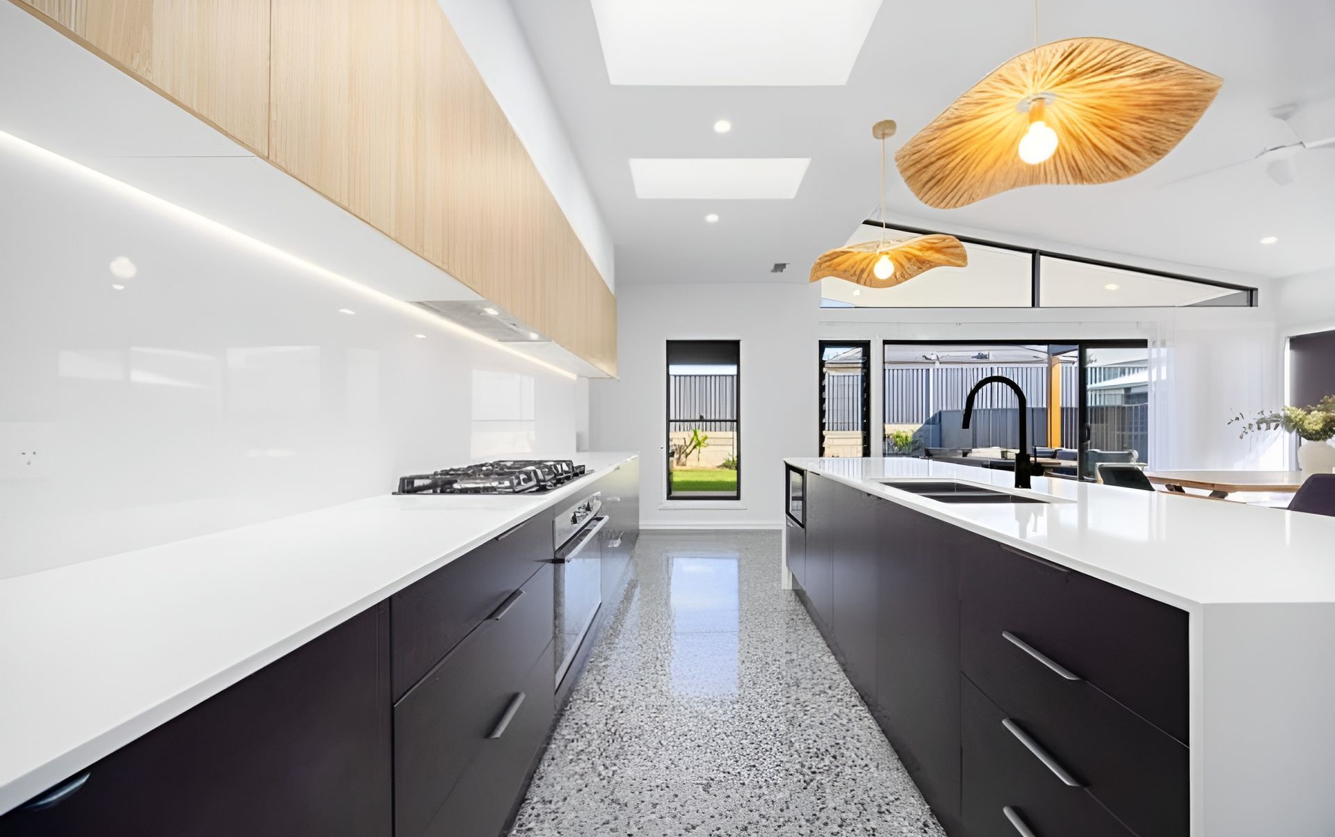 A Modern Kitchen With Dark Cabinetry — Coastbuilt Building Services in Thrumster, NSW